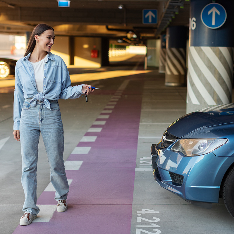 Abbildung zeigt Frau nach dem Einparken ihres Autos